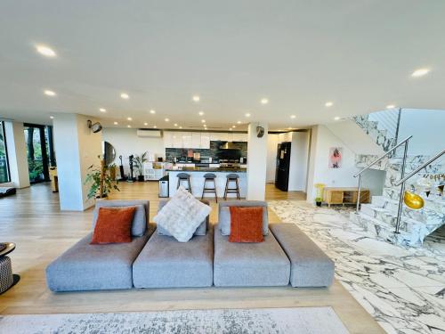 a living room with a couch and a kitchen at 6BR Stunning Waterview & Private Pool in Sydney