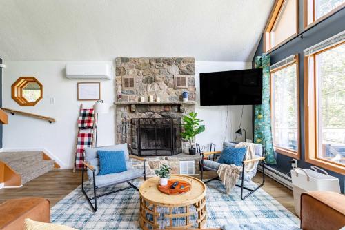 a living room with a stone fireplace and a tv at Blue Diamond Hot Tub Fire Pit 3 BDR in Tobyhanna