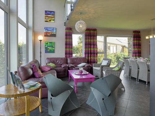 a living room with a couch and tables and chairs at Ovifat Sauna Escape, Waimes in Ovifat