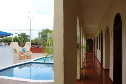 a house with a swimming pool in a courtyard at Hotel Campo Real Plus Tamasopo in Tamasopo