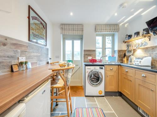 a kitchen with a washer and dryer at The Studio in Woolland
