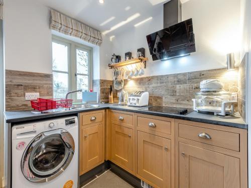 a kitchen with a washer and a washing machine at The Studio in Woolland