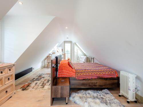 a bedroom with a bed with an orange blanket at The Studio in Woolland