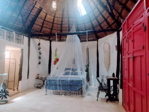 a bedroom with a bed in a tent at Hotel y Museo Aldea Maya Toktli Orígenes - Suite La Casa Maya - Alberca, Wifi Starlink, Tour Museo in Izamal