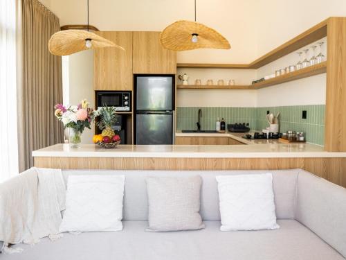 a living room with a couch and a kitchen at Aquae Villas - Palma - Luxury and Cozy 1bdr Villa - Kuta Lombok in Kuta Lombok
