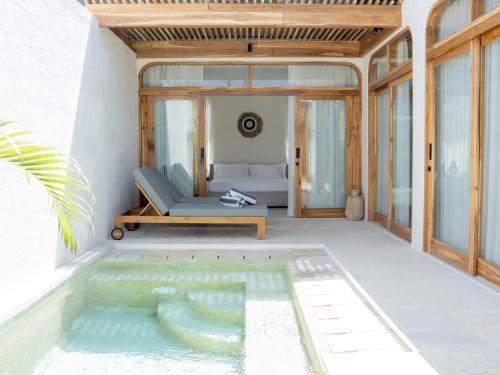 a pool in the middle of a patio with a couch at Aquae Villas - Palma - Luxury and Cozy 1bdr Villa - Kuta Lombok in Kuta Lombok