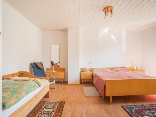 a bedroom with two beds and a chair in it at Countryside Stay in Meisdorf in Meisdorf