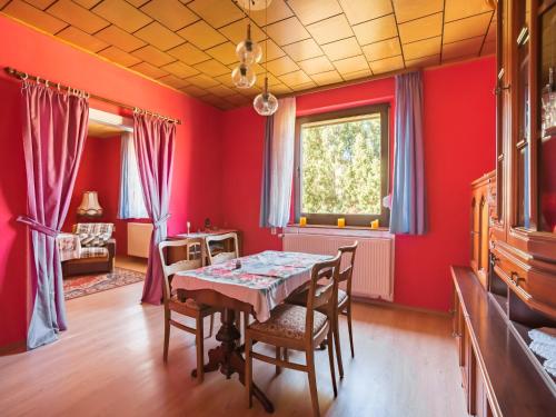 a dining room with red walls and a table and chairs at Countryside Stay in Meisdorf in Meisdorf