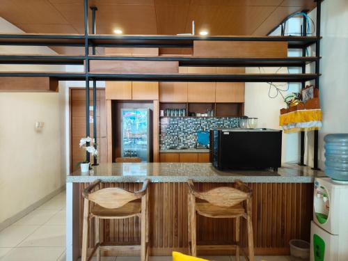 a kitchen with a bar with two stools at Sapo Jimbaran Bali in Jimbaran