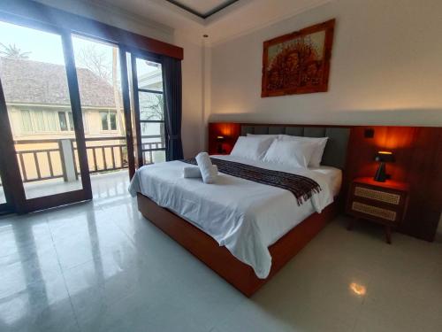 a bedroom with a large bed and a large window at Artha Sadia Villa 1 Seseh Beach in Cemagi