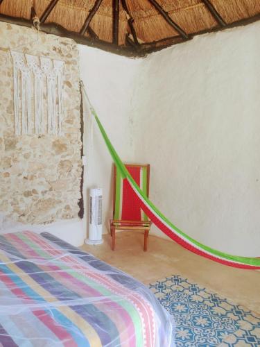 a room with a bed and a green rope at Hotel y Museo Aldea Maya Toktli Orígenes - Casa Maya Del Toloque Coronado - Alberca, Wifi Starlink, Tour Museo in Izamal