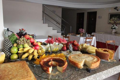 einen Tisch mit einem Haufen verschiedener Brotsorten und Obst in der Unterkunft Hotel Central in Vitória da Conquista
