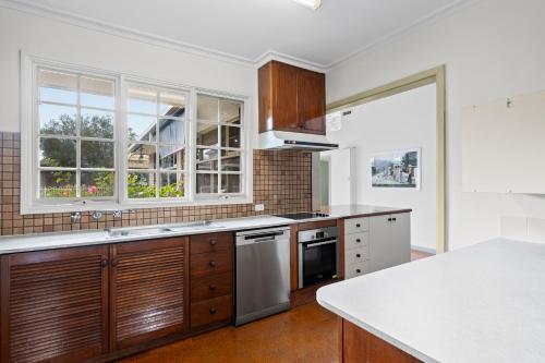 a kitchen with wooden cabinets and stainless steel appliances at Hampton Spacious House & Pool in Melbourne