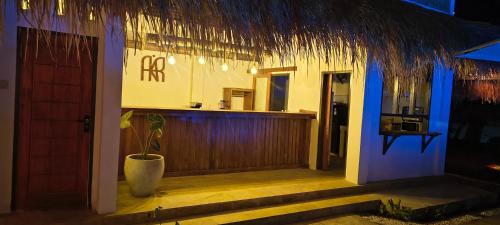 Una entrada a un restaurante con un bar y una planta. en Akarair, en Gili Air