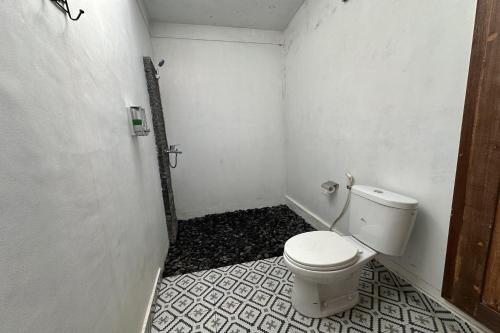 a bathroom with a toilet in a small room at Mahayana Guest House in Tegalalang