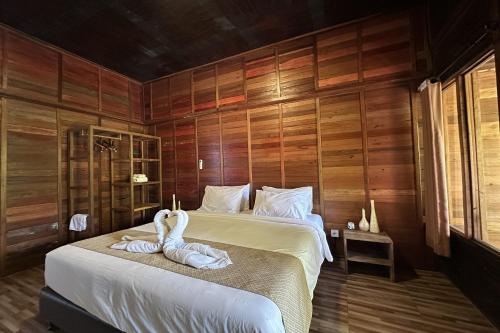 a bedroom with two swans sitting on a bed at Mahayana Guest House in Tegalalang