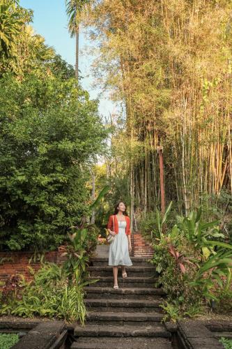 a woman is walking up some stairs at La Résidence Phou Vao in Luang Prabang