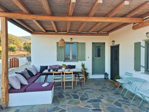 a patio with a purple couch and a table at The old barn, Naousa Paros in Naousa