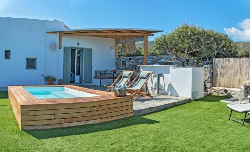a backyard with a swimming pool and a house at The old barn, Naousa Paros in Naousa