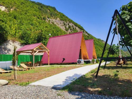 a group of colorful buildings in front of a hill at HARMONY- ჰარმონია in Ambrolauri