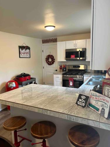 a kitchen with a large counter with stools in it at Authentic Remodeled Taber Street Railroad House in Williams
