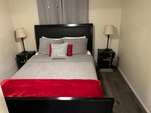 a bedroom with a bed with a red blanket and two lamps at Authentic Remodeled Taber Street Railroad House in Williams