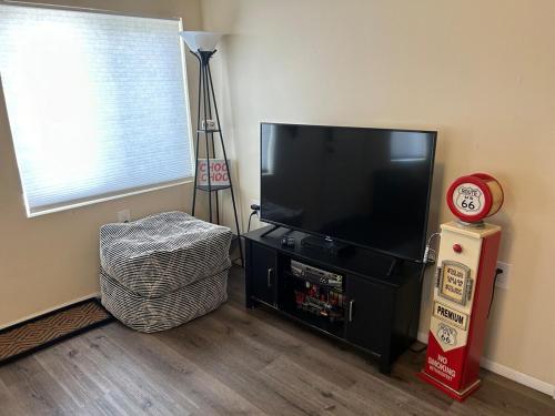 a living room with a flat screen tv and a clock at Authentic Remodeled Taber Street Railroad House in Williams