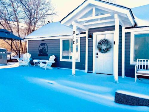 a house with a white door and a table and chairs at Authentic Remodeled Taber Street Railroad House in Williams