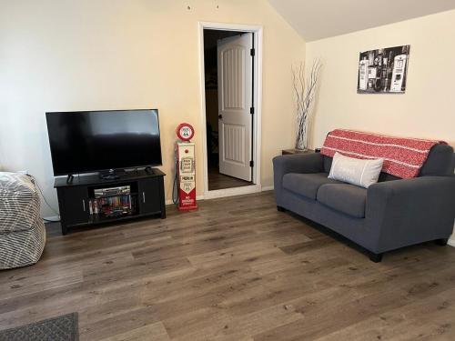 a living room with a couch and a flat screen tv at Authentic Remodeled Taber Street Railroad House in Williams