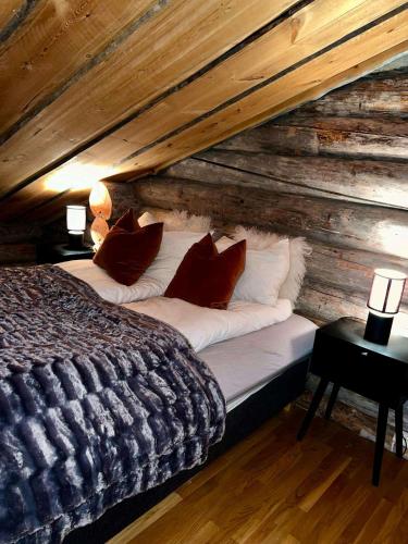 a bedroom with a bed in a log cabin at Aurora Bliss Cabin Retreat in Kilpisjärvi