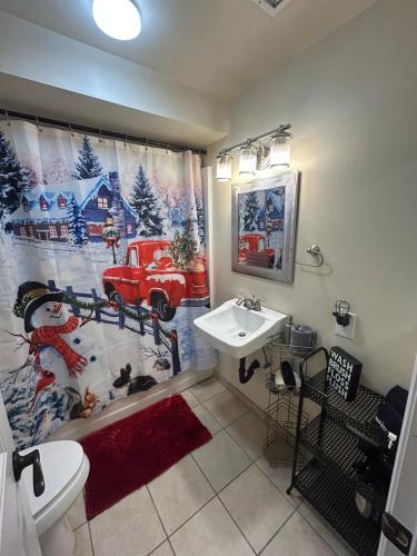 a bathroom with a christmas shower curtain and a sink at Authentic Remodeled Taber Street Railroad House in Williams