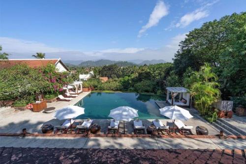 an image of a swimming pool with chairs and trees at La Résidence Phou Vao in Luang Prabang