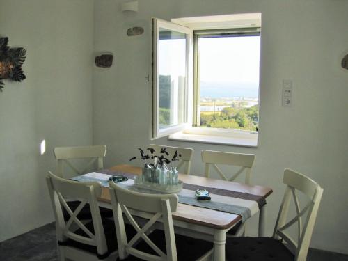 a dining room with a table and chairs and a window at The old barn, Naousa Paros in Naousa