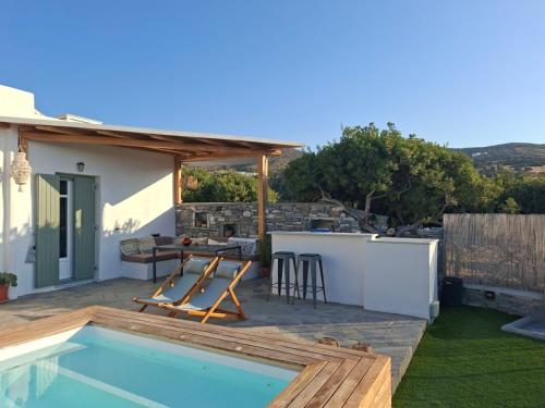a patio with a pool and a table and chairs at The old barn, Naousa Paros in Naousa
