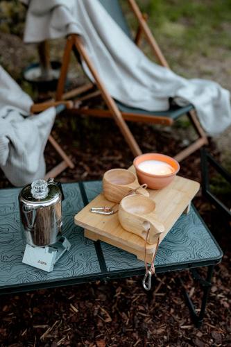 a table with a wooden tray with a bowl on it at Voodoo Glamping in Únětice