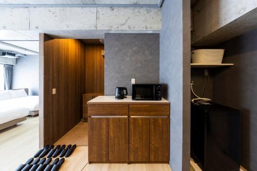 a room with a kitchen with a microwave and a bed at Amp Flat Arc Bliss 3 in Chikushino