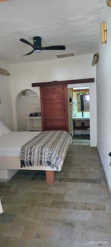 Un dormitorio con una cama y un ventilador de techo. en Akarair, en Gili Air
