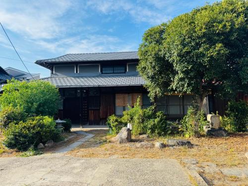 a house with a tree in front of it at 藤花楼akagawa 登録文化財 in Osaka
