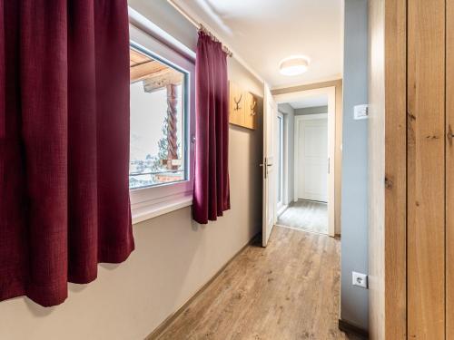 a hallway with red curtains and a window at Chalet in Bruck near Ski Slopes in Bruck an der Großglocknerstraße
