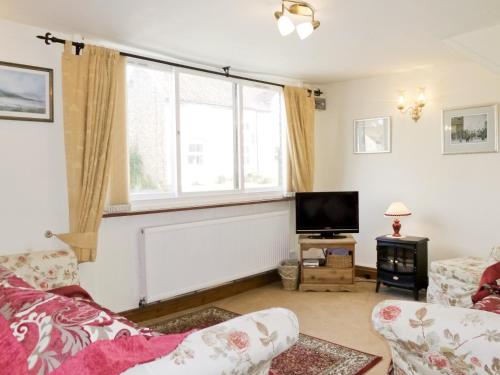 a living room with a couch and a tv at The Old Coach House in Burythorpe