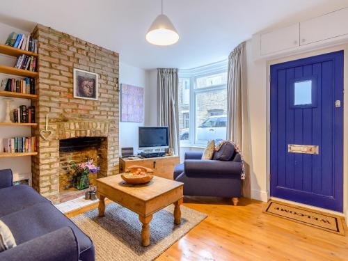 a living room with a blue door and a fireplace at Anchor Cottage in Whitstable