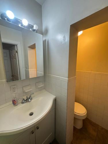 a bathroom with a sink and a toilet and a mirror at Park Ave Cottage Barn in New York