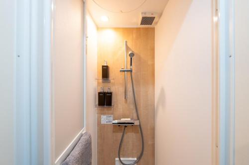 a bathroom with a shower in the corner of a room at 光 和風お風呂を楽しむお宿 usjまで電車で1分 駐車場付き ベッド6台 寝室3つ バスルーム2台 in Osaka