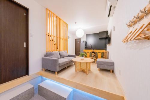 a living room with a couch and a table at 光 和風お風呂を楽しむお宿 usjまで電車で1分 駐車場付き ベッド6台 寝室3つ バスルーム2台 in Osaka