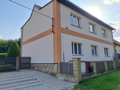 a white and orange house with a fence at H apartment in Jankov