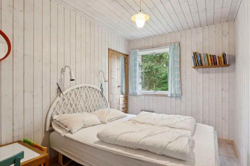 a white bed in a room with a window at Cozy Holiday Home Close To The Beach in Thyholm