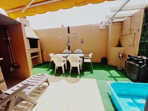 una camera con tavolo, sedie e piscina di Ideal for Families-Children's Play Area, Terrace, BBQ, WiFi a San Isidro
