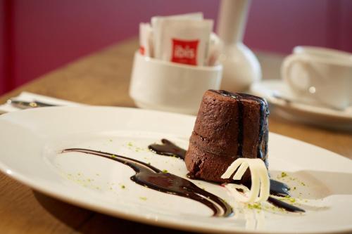 a piece of chocolate cake on a plate with a fork at Ibis Konya in Konya