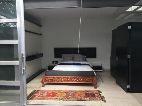 a bedroom with a bed and a rug on the floor at Casa Dodi Loft in Juriquilla Design oasis in Juriquilla