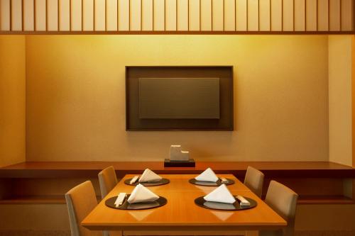 a dining room with a table and a flat screen tv at Hyatt Regency Tokyo in Tokyo